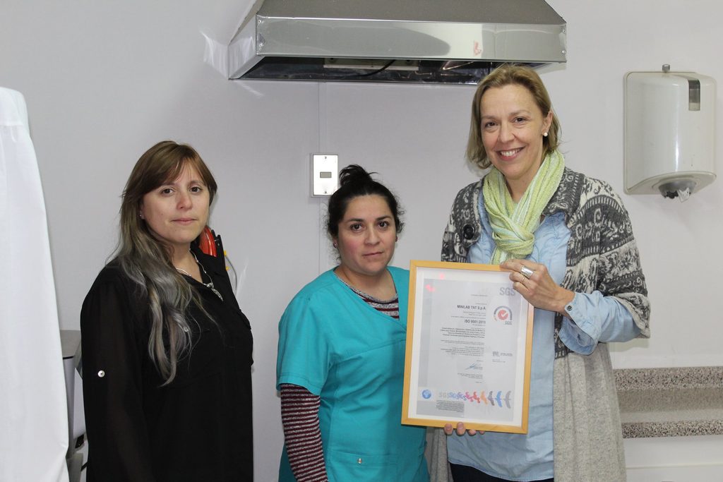 Representantes de Minilab TNT SpA exhibiendo su certificado ISO 9001:2015.